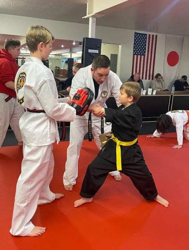 instructor showing a student proper jiu jitsu etiquette 