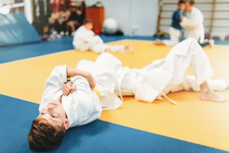 Kids Brazilian Jiu Jitsu class practicing ground techniques on mats in dojo